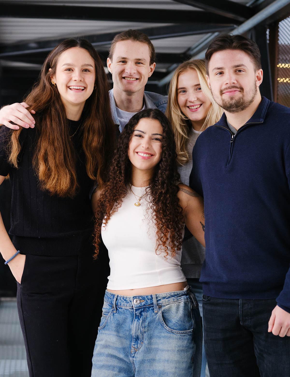 Fem studenter smiler mot kamera