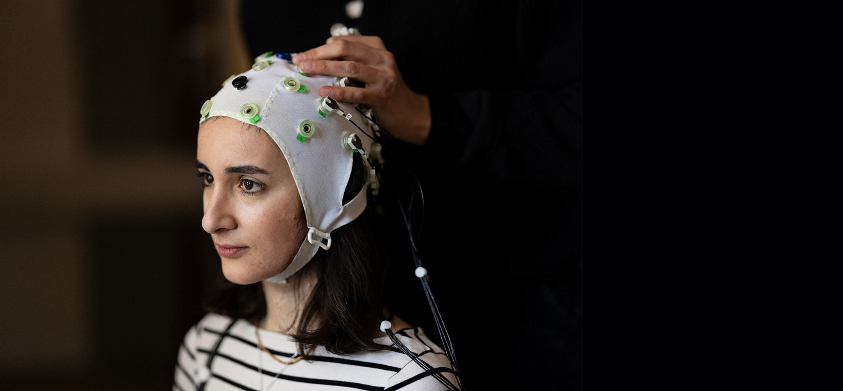 Forsker plasserer elektroder på hodet til en dame under forskning. Foto