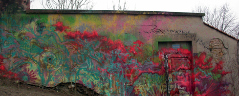 Bilde av en murvegg dekt av grafitti. 