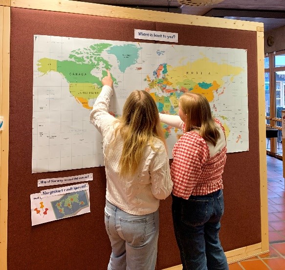 Foto. To studenter peker på et verdenskart.