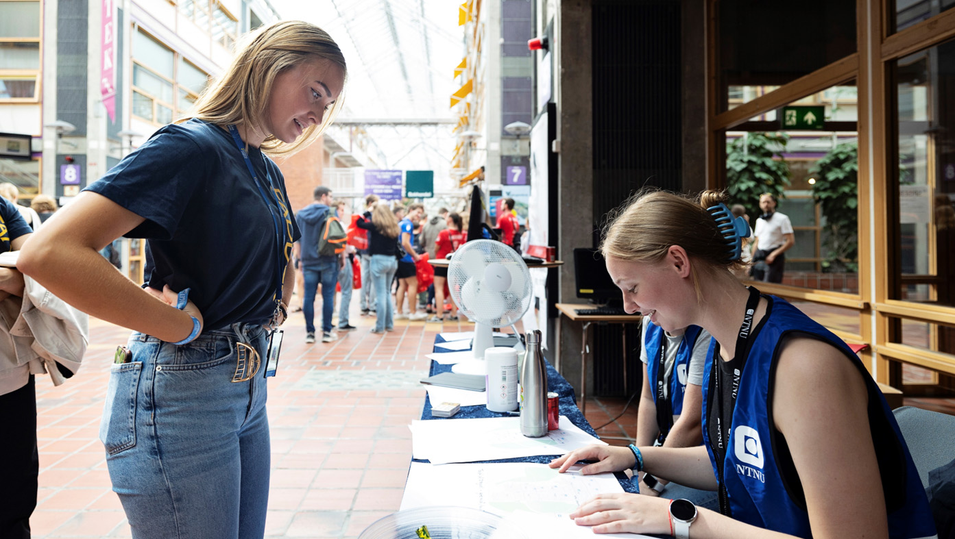 Student spør campusvert i gata på Dragvoll. Foto