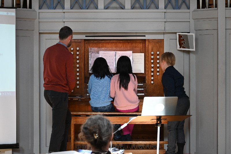 Barn spiller orgel, lærer følger med.