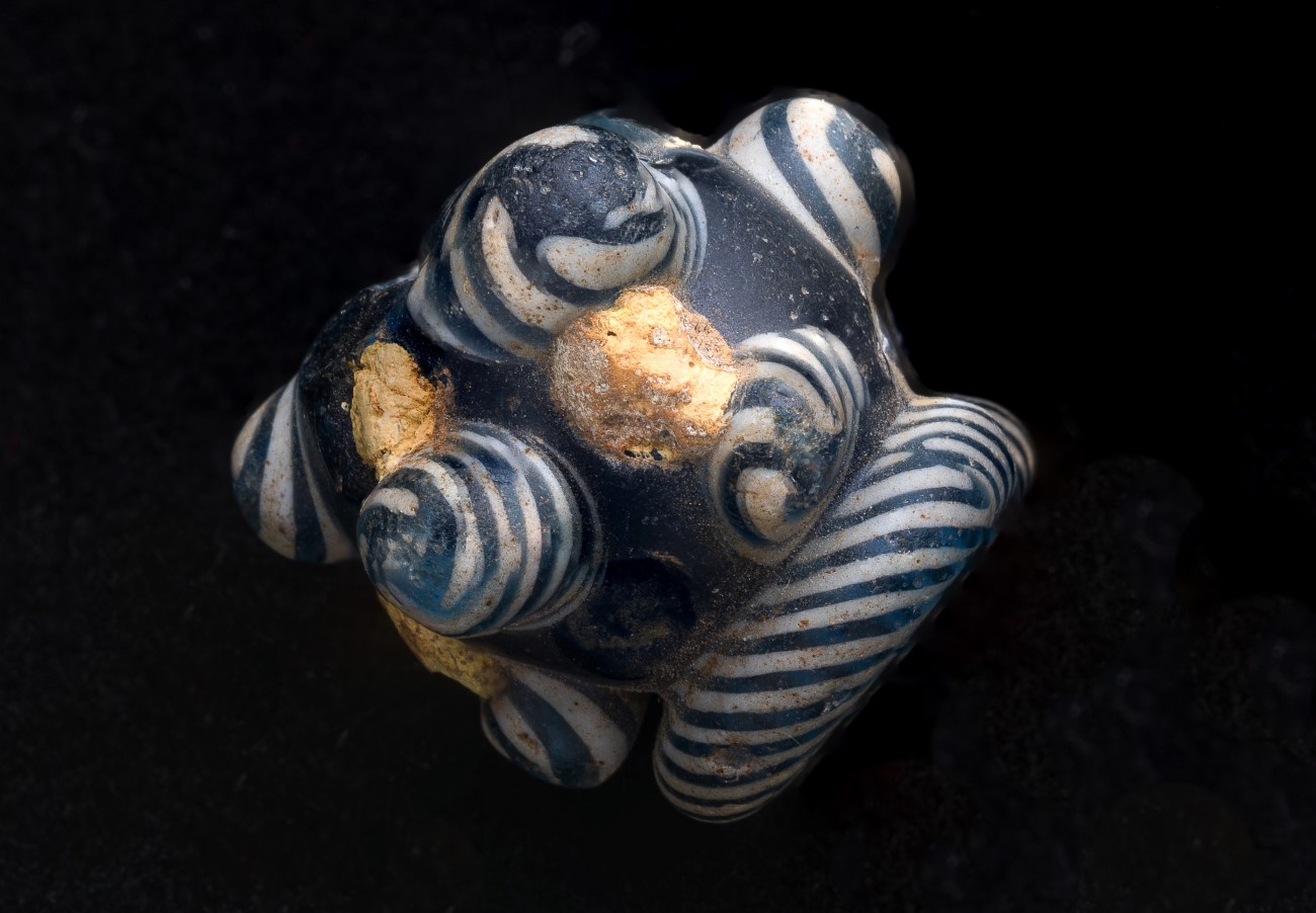 Blå og hvit orientalsk perle fra vikingtid. Foto Åge Hojem, Vitenskapsmuseet.