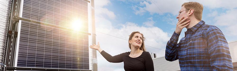 To personer står foran solcellepanel