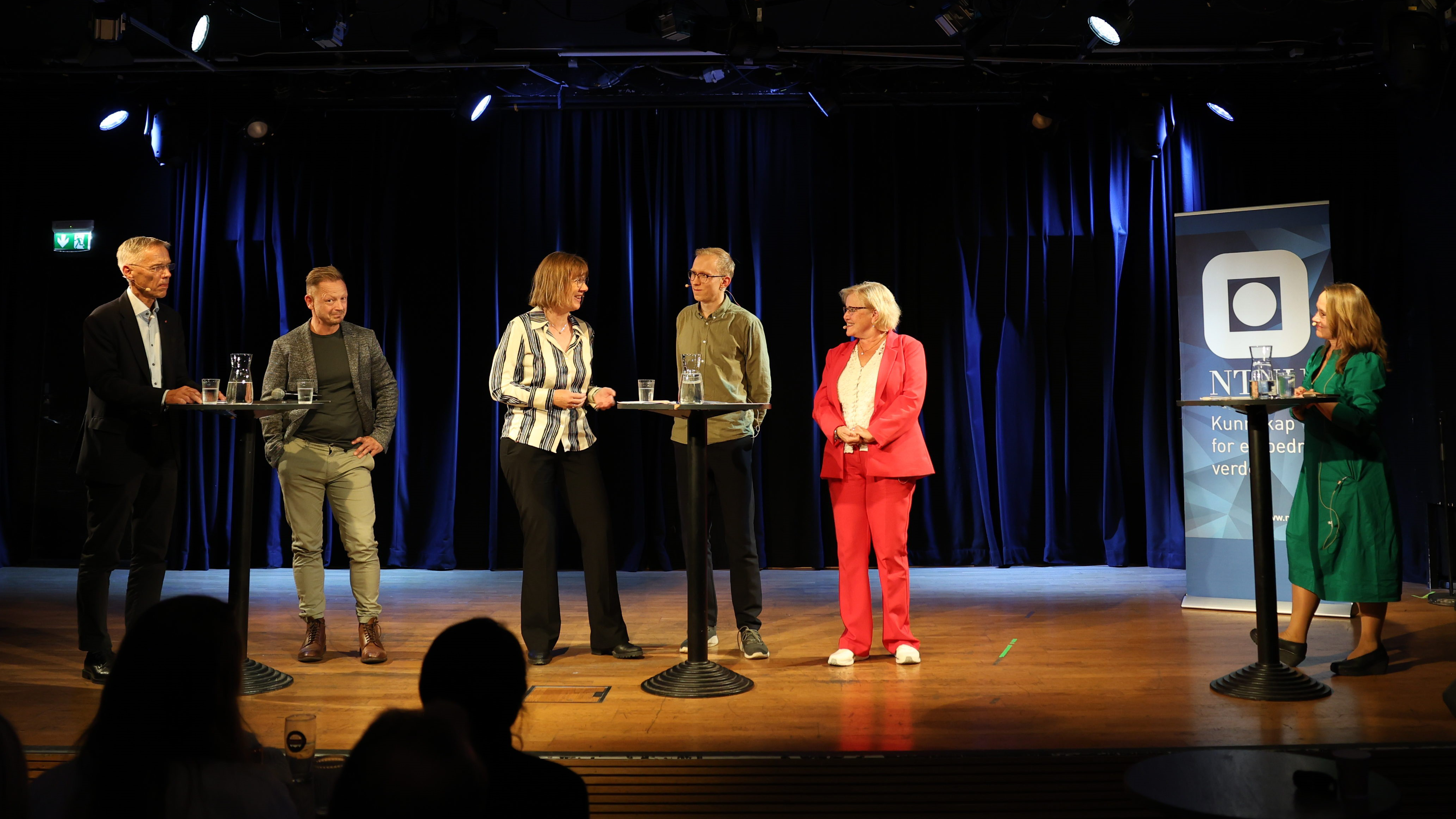 Mennesker som debatterer på en scene ved Dokkhuset. Foto: NTNU