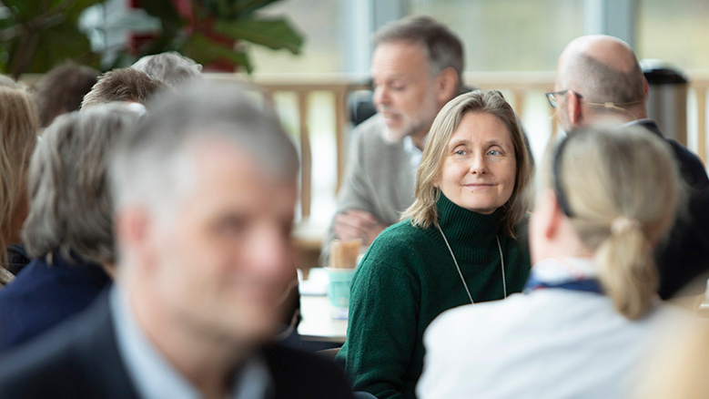 Personer som sitter rundt bord og diskuterer. Foto: NTNU