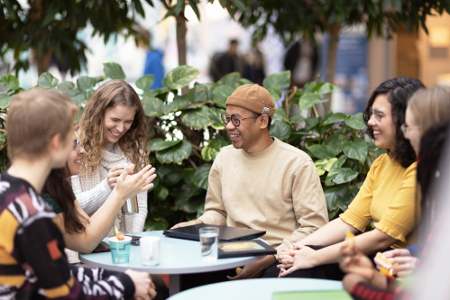 Studenter som sitter rundt et bord og prater