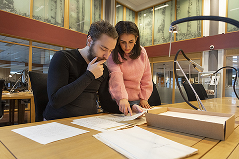 To studenter studerer et historisk dokument.  Foto