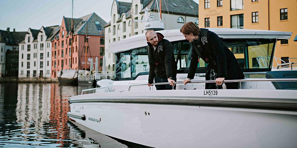 To studenter på skipsdesign sjekker ut lystbåt på havna i Ålesund. Foto: Tone Molnes/NTNU