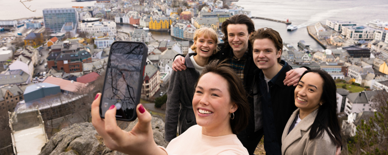 Studenter tar selfie med utsikt over Ålesund. 