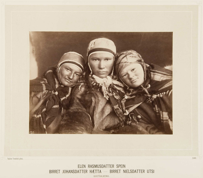 Tre samiske kvinner ser mot kamera. Foto
