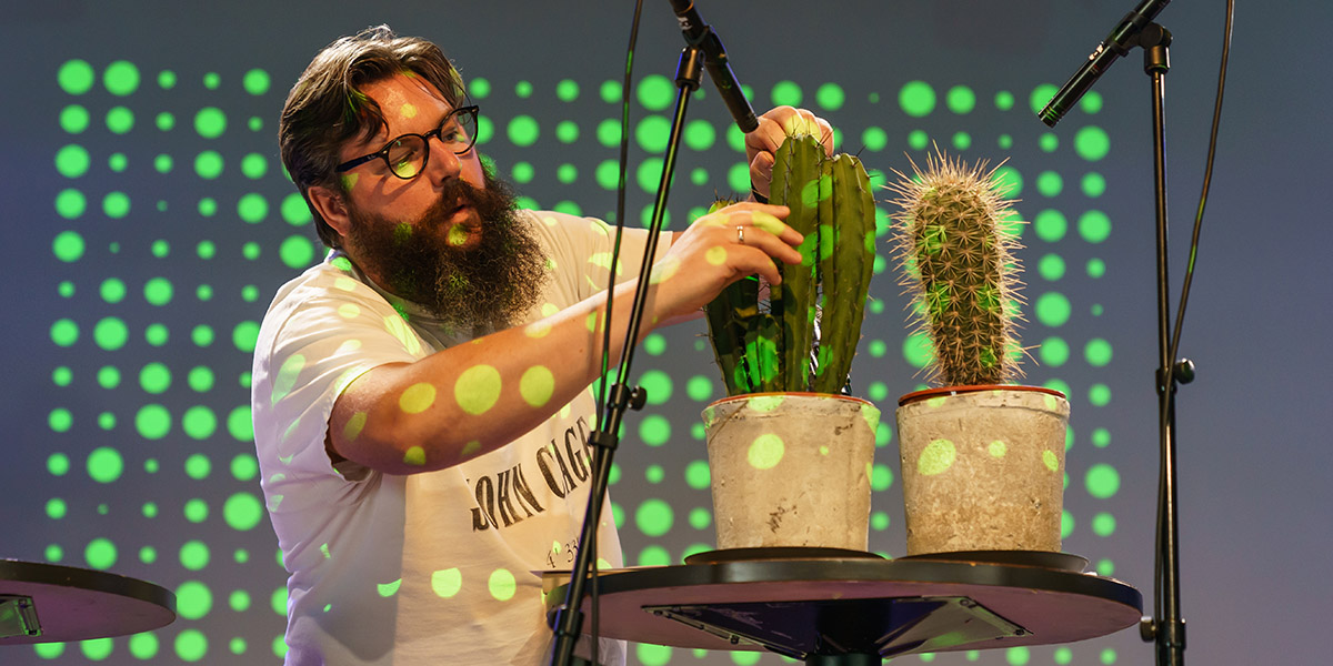  Professor Michael Duch puts two microphones up against two cacti.