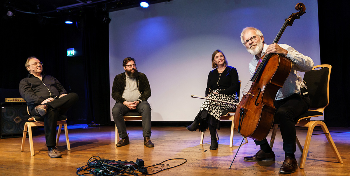  Three people listen to Øyvind Gimse playing the cello.