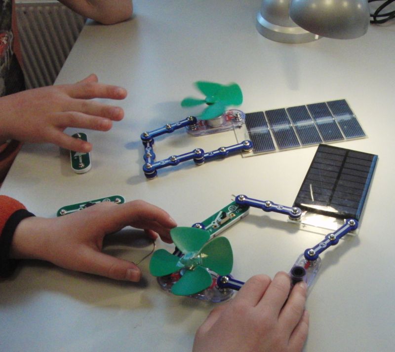 Elever som tester ut solceller og vifter i elektriske kretser. Foto.