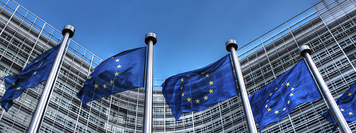 EU flag against blue sky in Brussels.