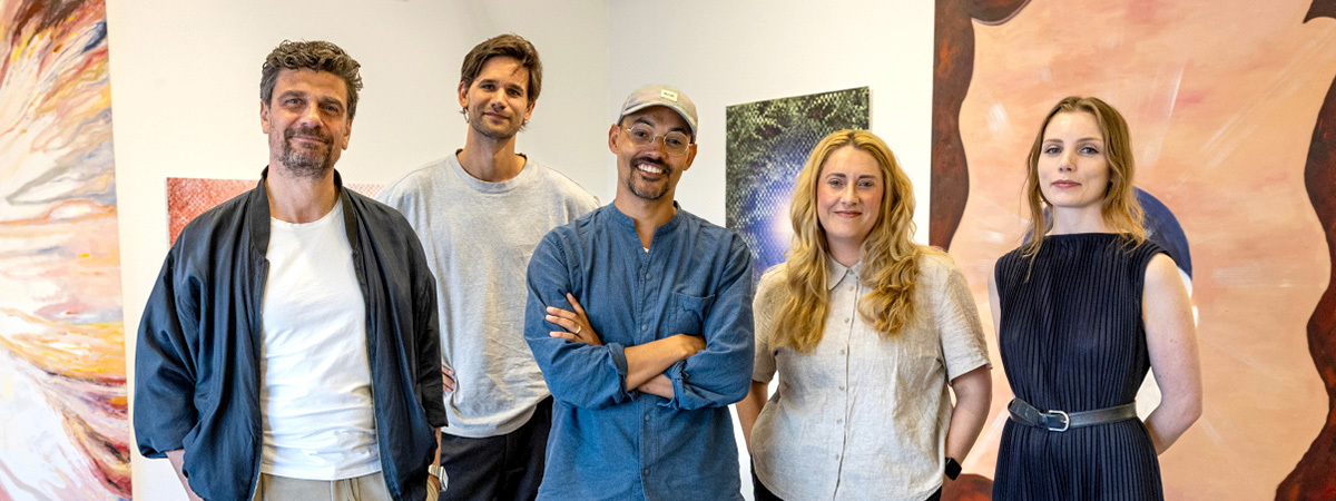 A group of men and women in a line, looking directly into the camera.