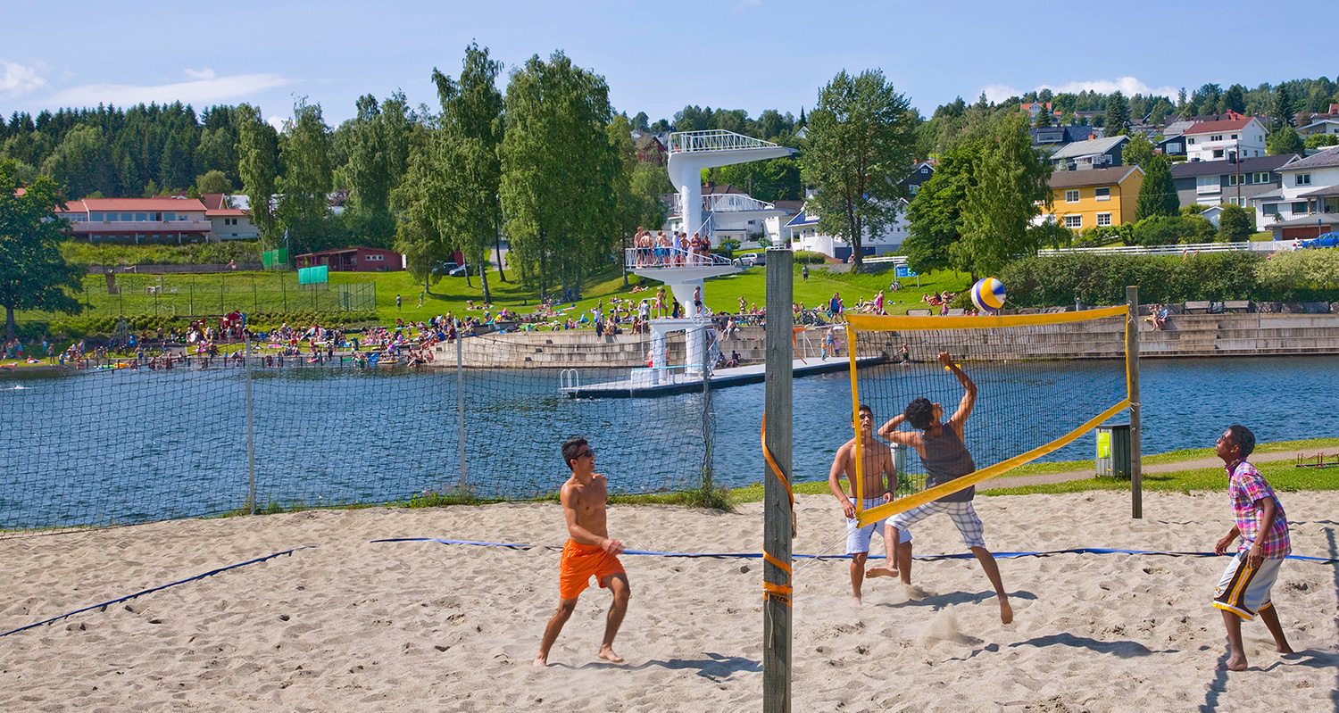 Studentar spelar volleyball ved badeanlegget Fastland midt i byen.