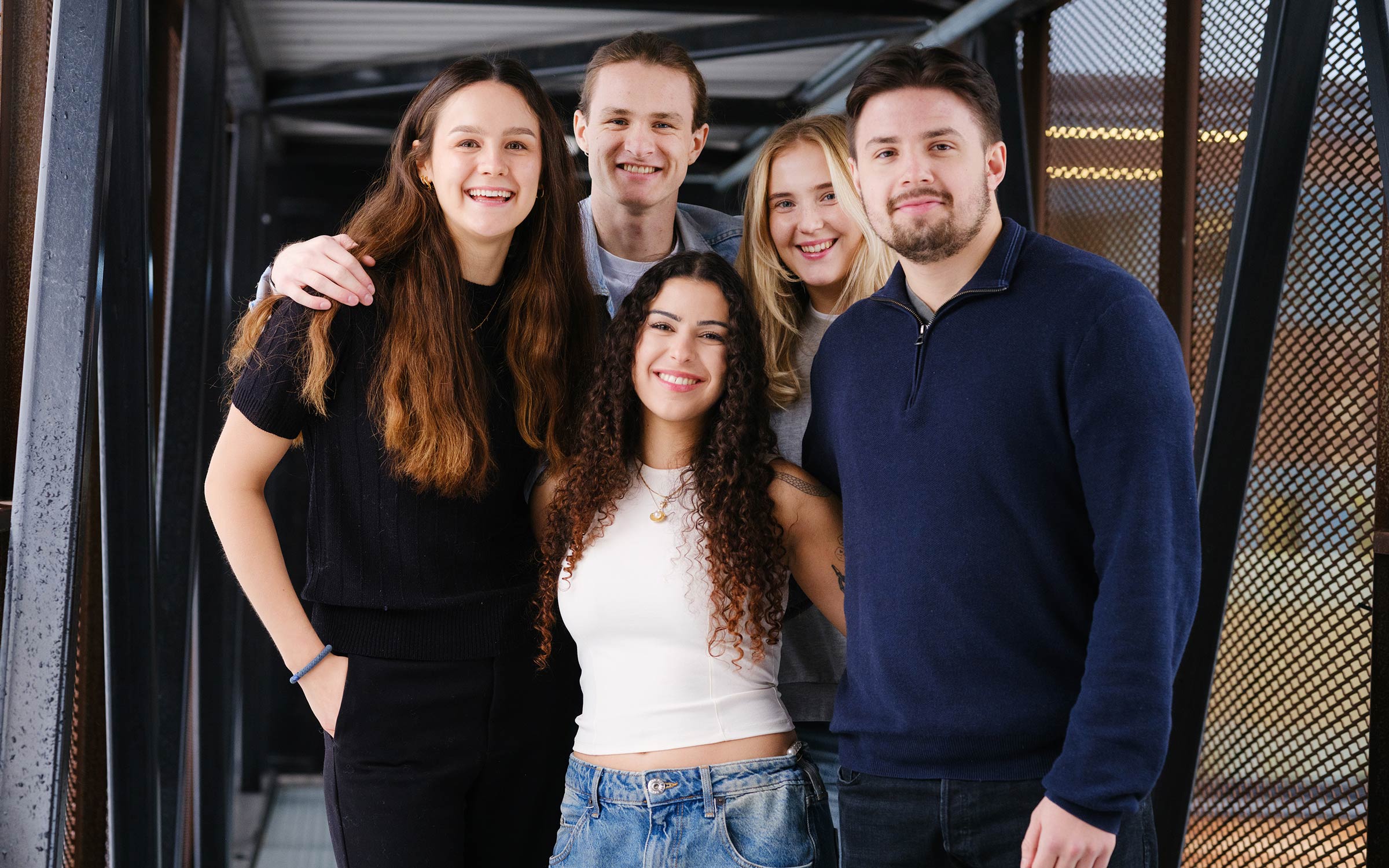 Fem studenter smiler mot kamera